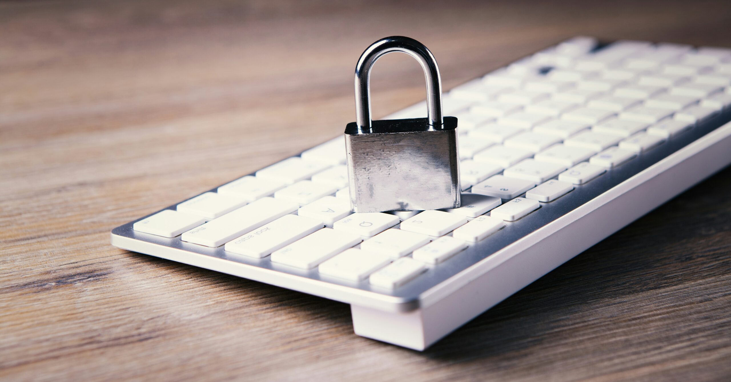 Remote-Work-Security-Revisited_-Advanced-Strategies-for-Protecting-Your-Business-in-2025-scaled.jpg a computer keyboard with a padlock on top of it